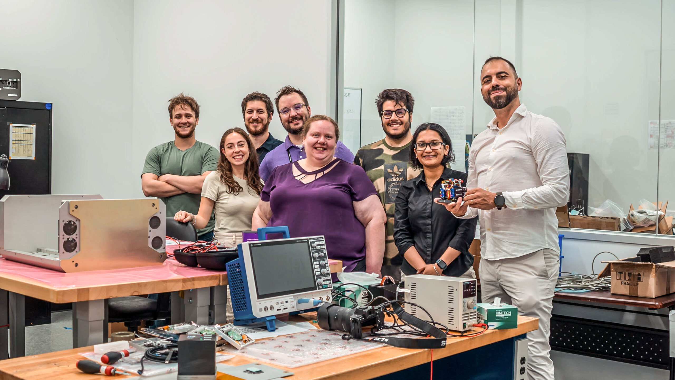 Diverse team of engineers smiling in electronics lab