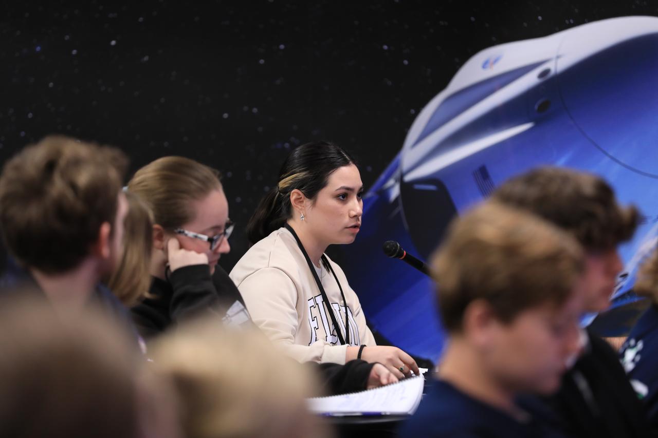 Woman speaking at space-themed conference panel