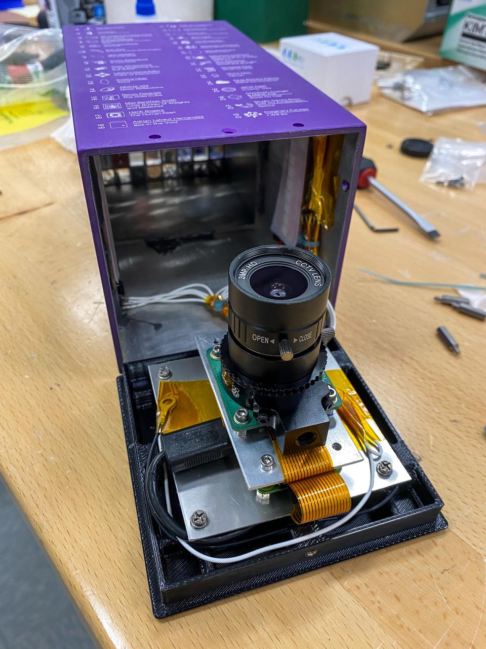Open purple device displaying internal camera and electronics