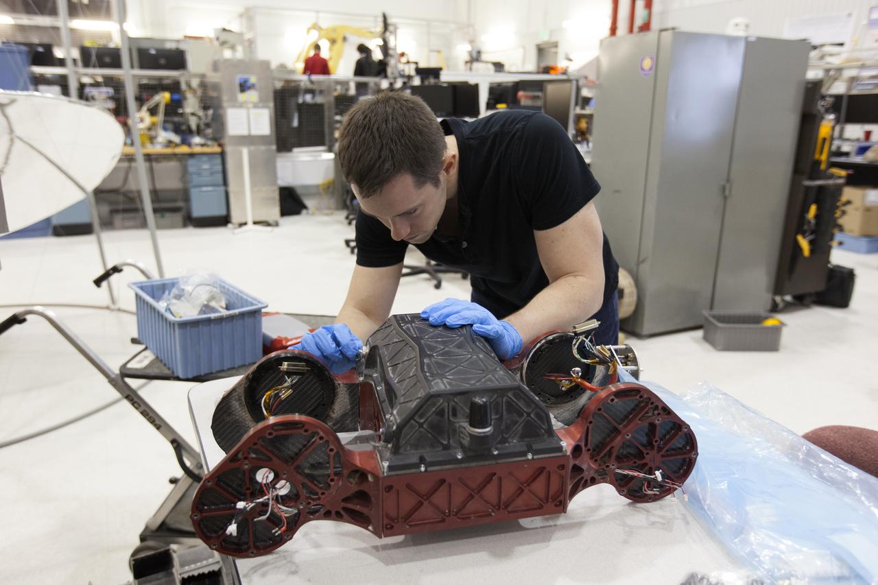 Engineer assembling robotic vehicle in high-tech lab