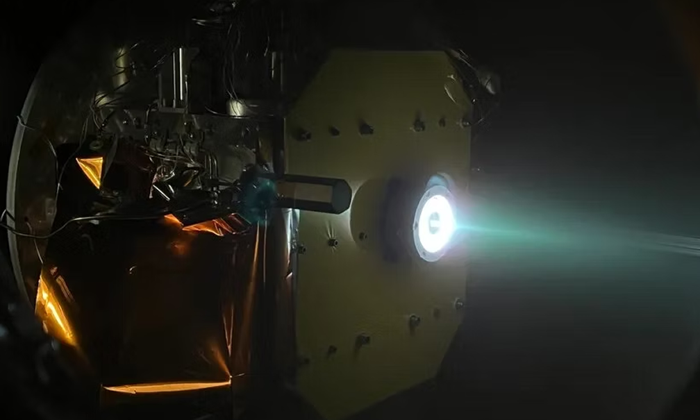 Spacecraft ion thruster emitting bright blue beam