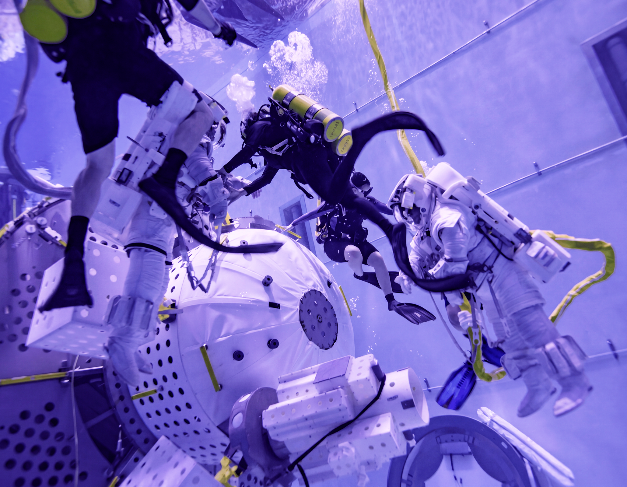 Astronauts training underwater with scuba divers.