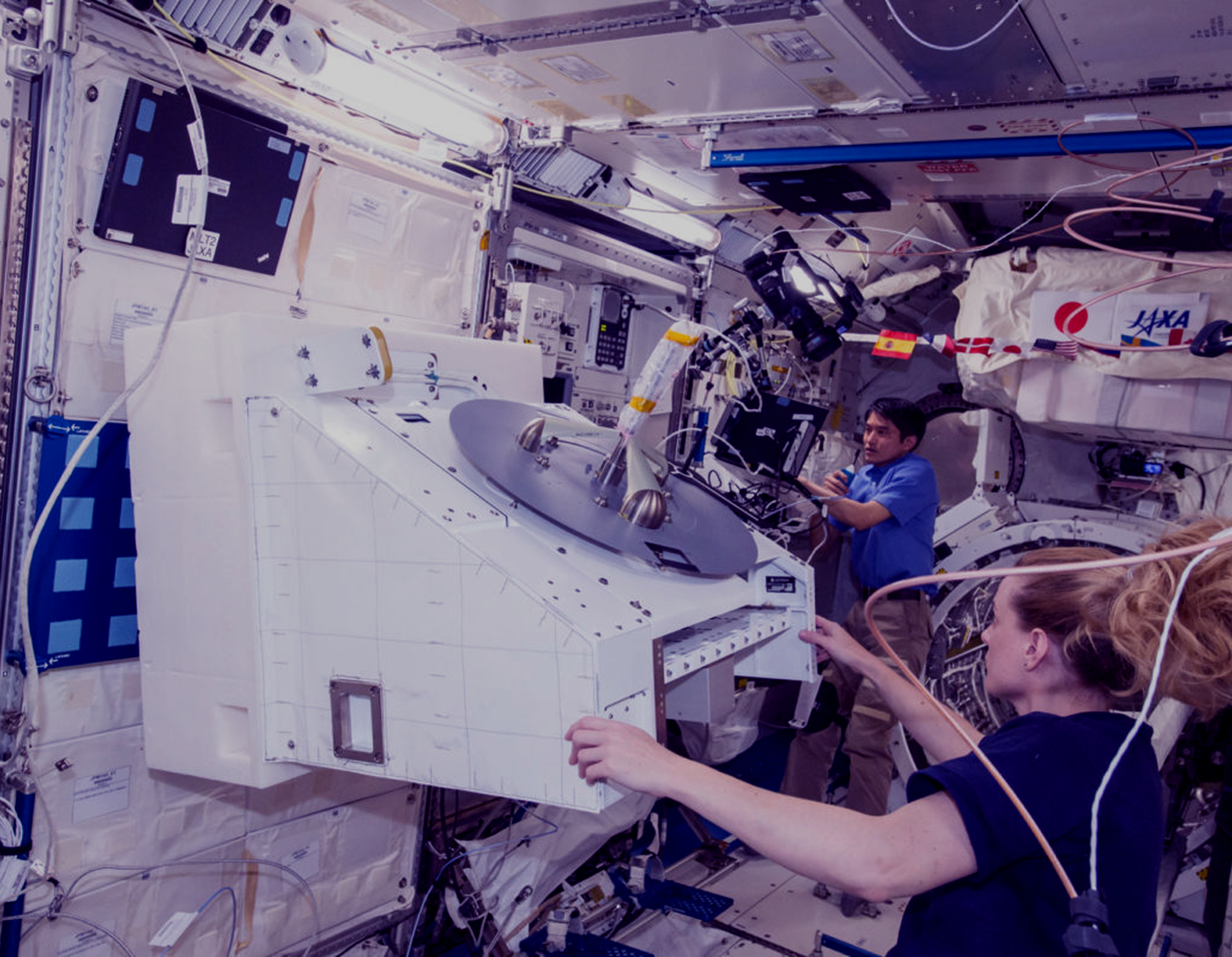 Astronauts working inside the space station laboratory.