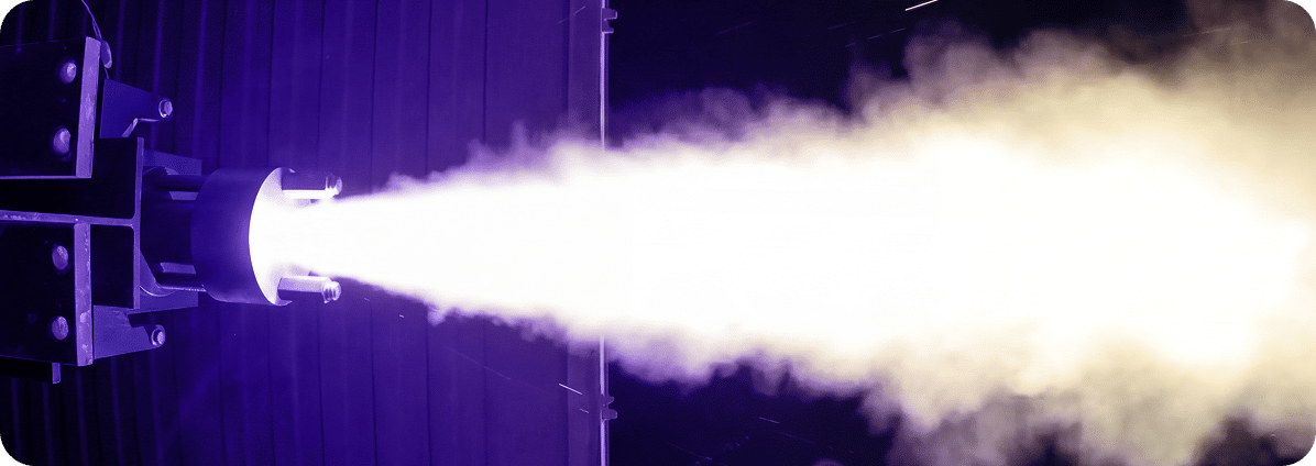 Rocket engine test firing with blue flame.