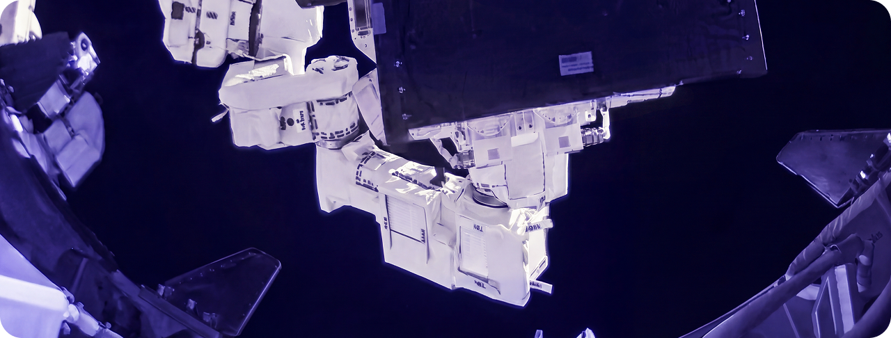 Astronaut in space suit working outside spacecraft in space.